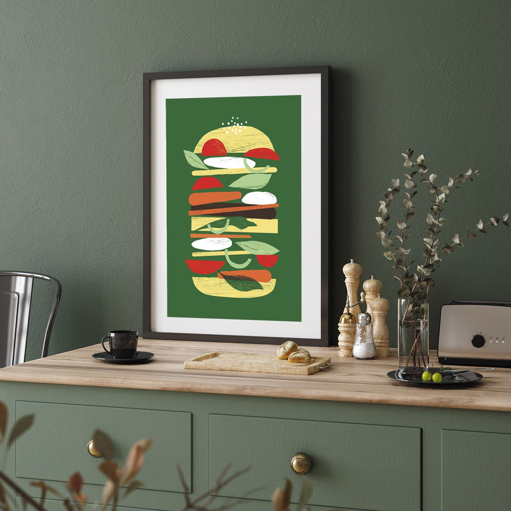 Art print of a burger leaning on a countertop against a green wall.