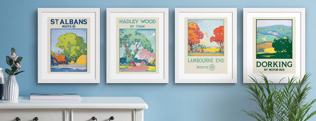 Poster prints and travel posters, hung up on a light blue wall.