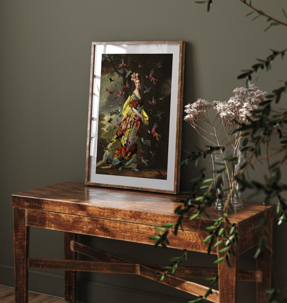 Wall art print of a woman and hummingbirds leaning against a green wall.