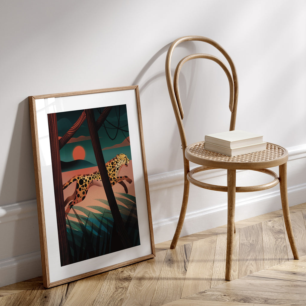 Vibrant art print featuring a cheetah sprinting through a forest at sunset. Art print is leaning against a wall next to a chair.
