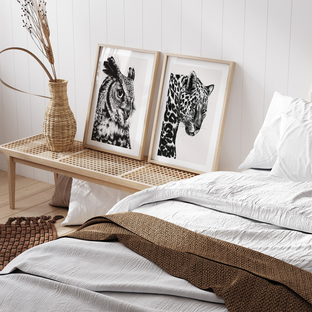 Beautiful art print featuring a detailed illustration of a leopard, in black and white. Art print id framed next to a bed and another picture.