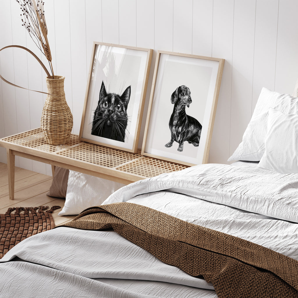 Monochrome art print featuring a detailed illustration of a black cat. Art print is leaning against a panelled wall in a bedroom.