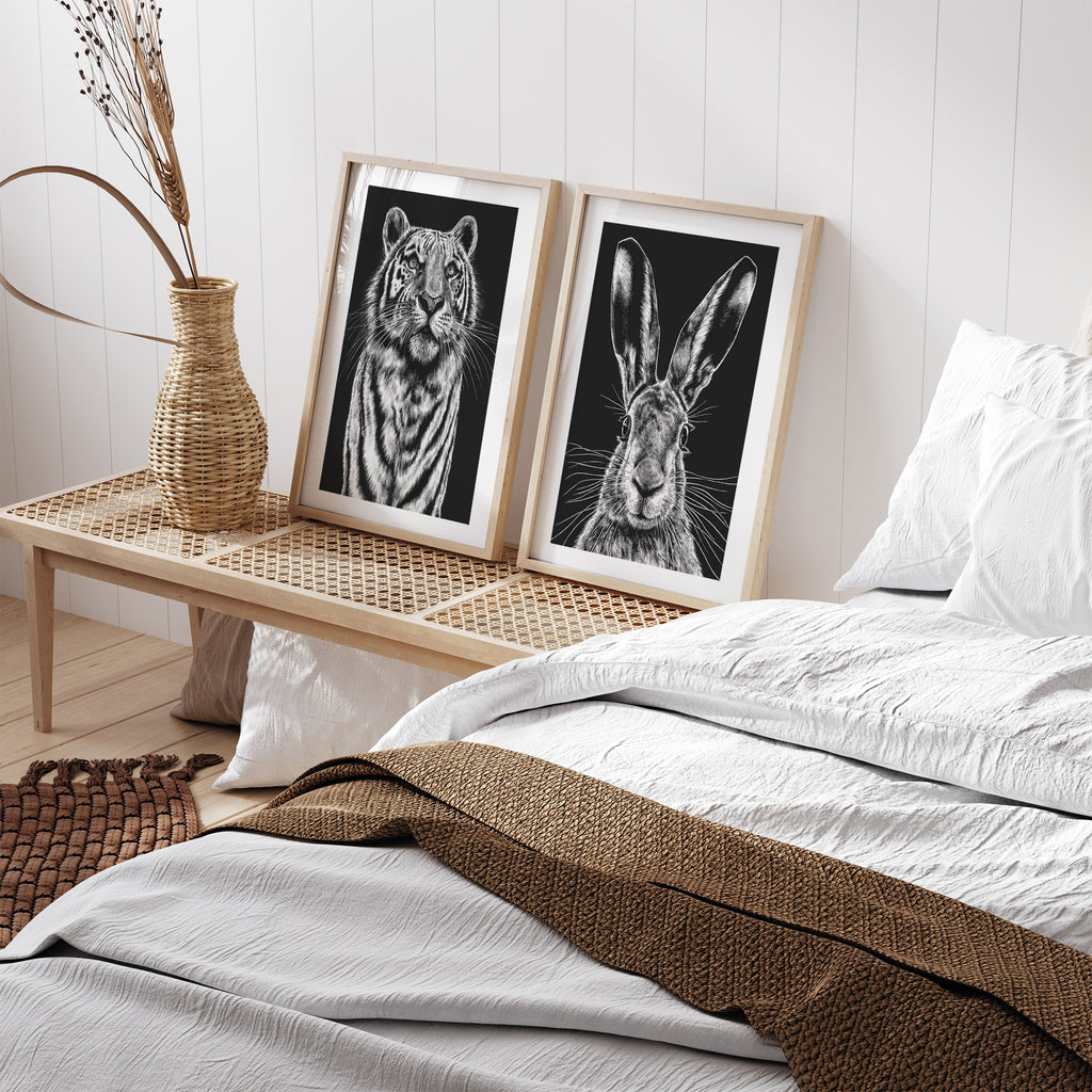Striking art print featuring a detailed illustration of a wild hare, in black and white. Art print is framed and sat in a bedroom.