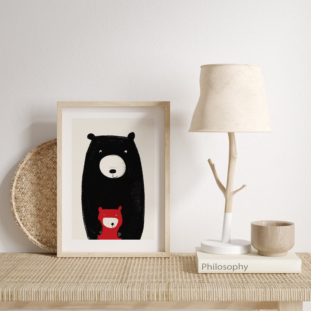 Minimalistic art print of big bear and baby bear posing together. Art print is leaning against a white wall next to a lamp.