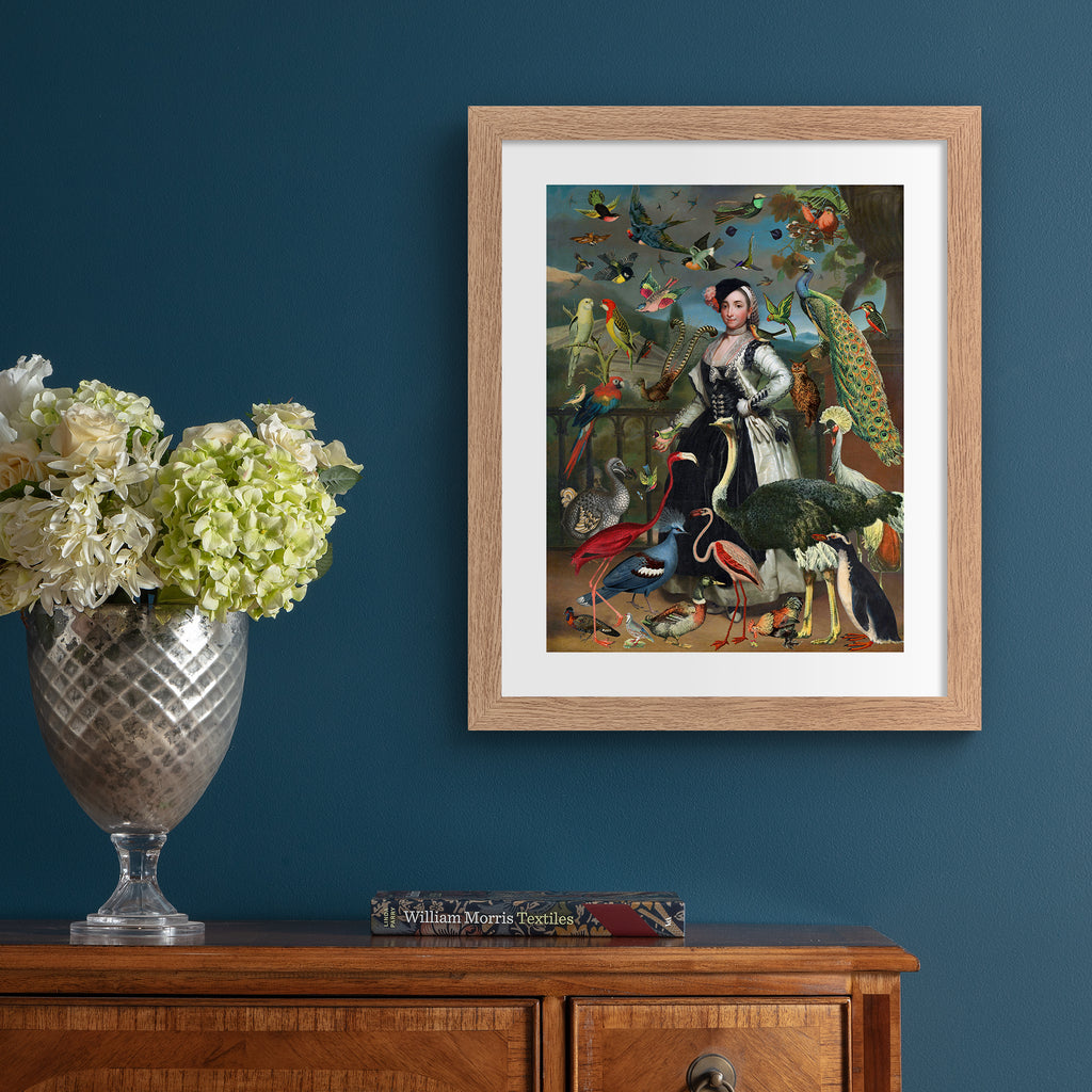 Stunning 'Pop-Surrealist' art print featuring a vast array of different birds flocking around an elegant woman. Art print is hung up on a blue wall.