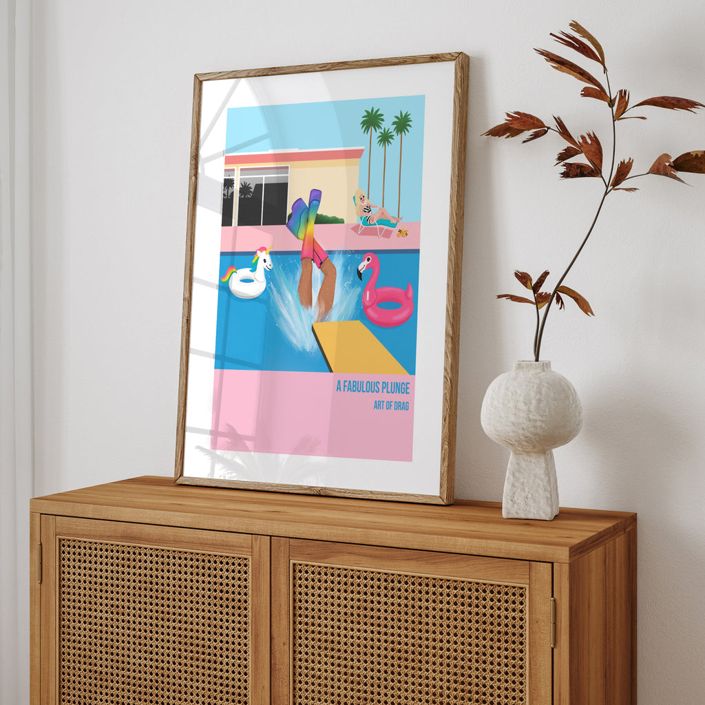Reimagined art print featuring a Drag Queen plunging into a pool, wearing rainbow boots. Art print is on a dresser, leaning against a white wall.