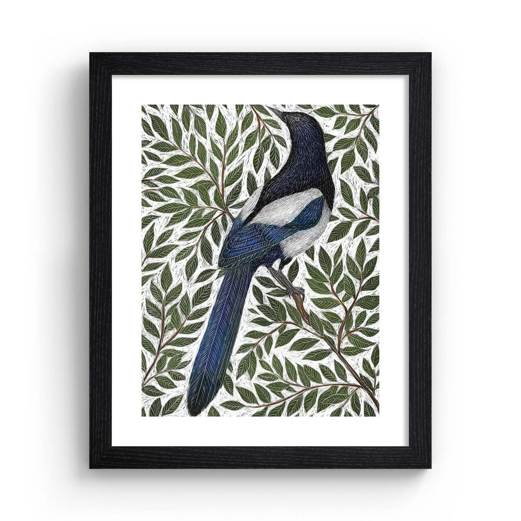 Nature art print featuring a detailed illustration of a magpie surrounded by green leaves and branches. Art print is in a black frame.