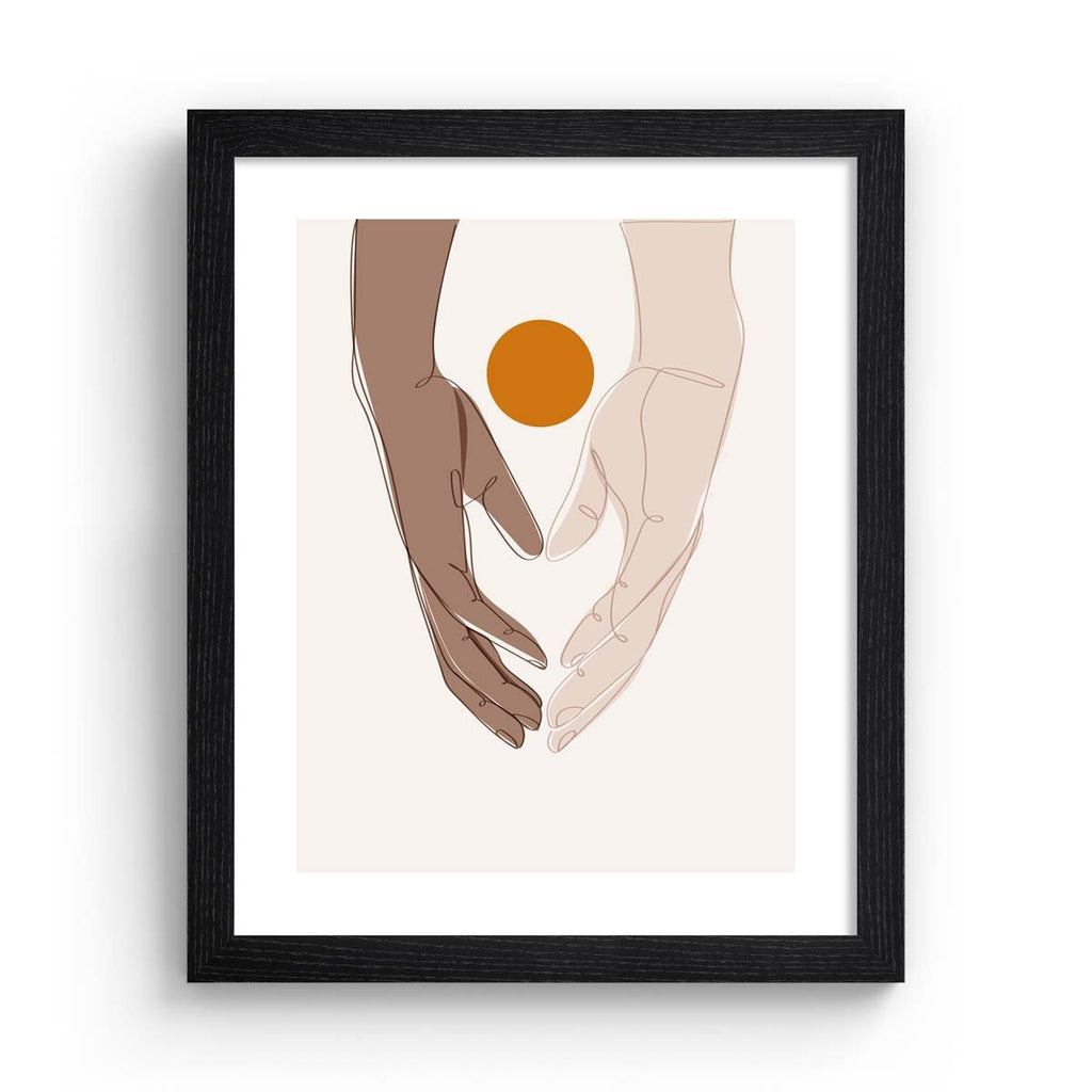 Beautiful art print featuring two hands meeting in the meeting of the frame. A bright sun sits behind the hands. Art print is in a black frame.
