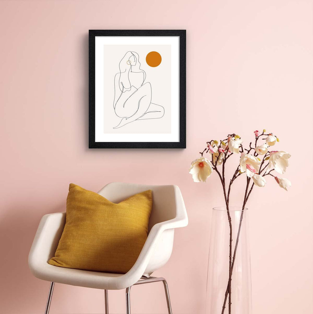 This beautiful art print contains clever line work creating the female form, accompanied by a splash of bright orange colour. Art print is hung up on a pale pink wall.