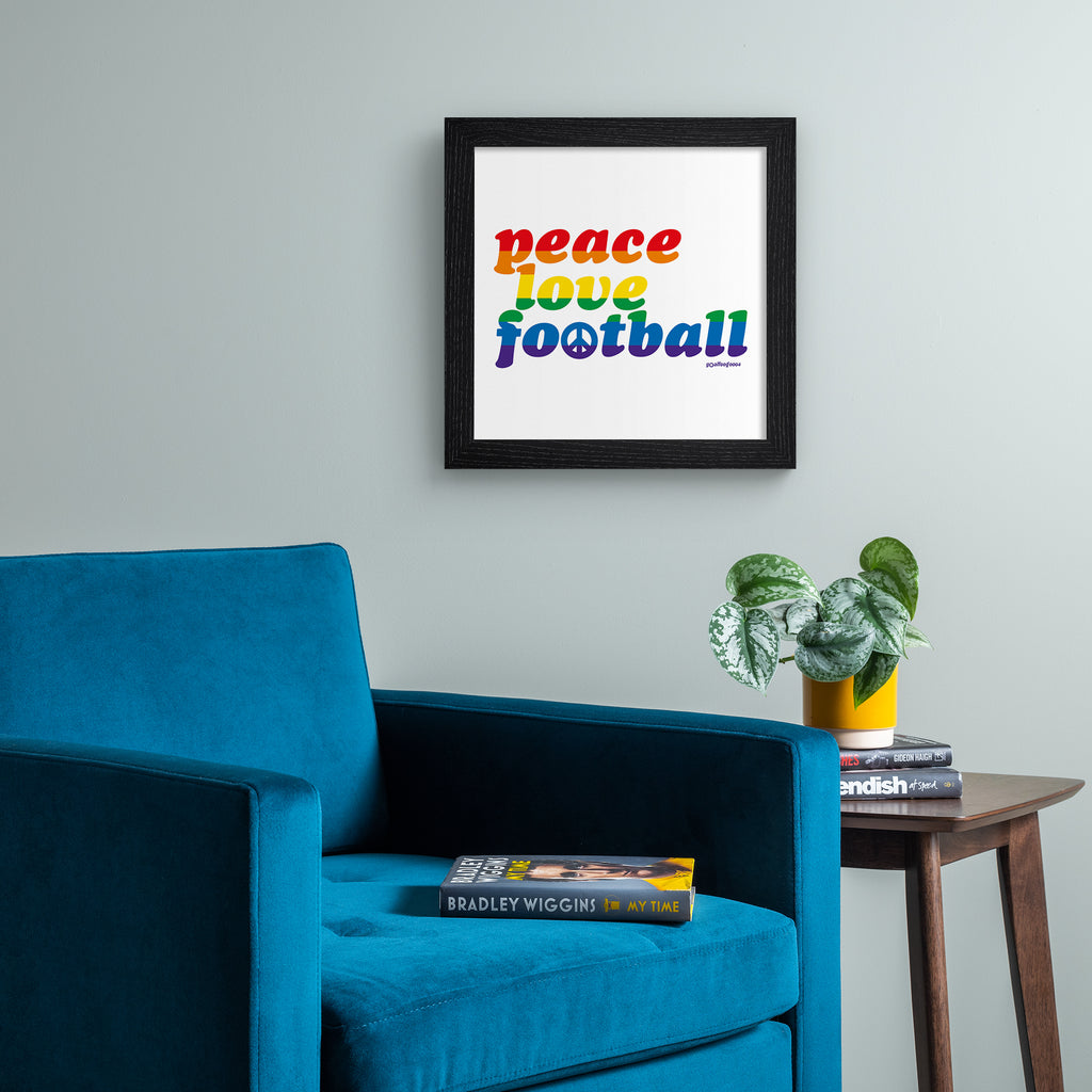Sporty typography art print celebrating football, stating 'peace, love, football' in multicoloured text. Art print is hung up on a grey wall.