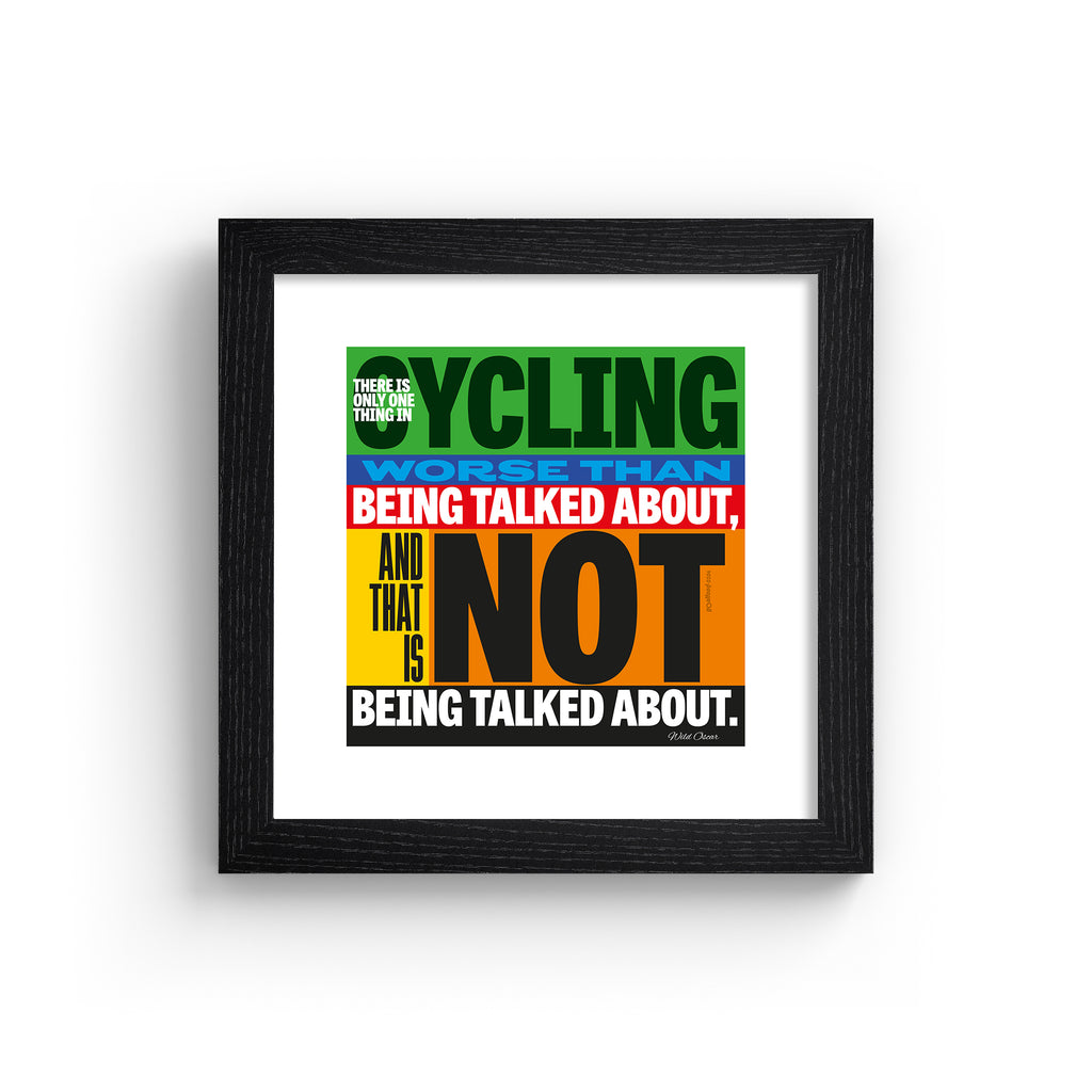 Sporty art print featuring typography celebrating cycling, on a multicolour background. Typography reads 'There Is Only One Thing In Cycling Worse Than Being Talked About, And That Is Not Being Talked About.' Art print is in a black frame.
