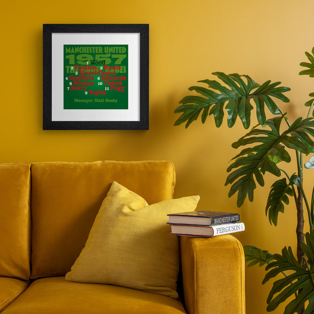 Sporty art print celebrating the Man United 1957 Team, on a bright green background, with red, black and green typography. Art print is hung up on an orange wall.