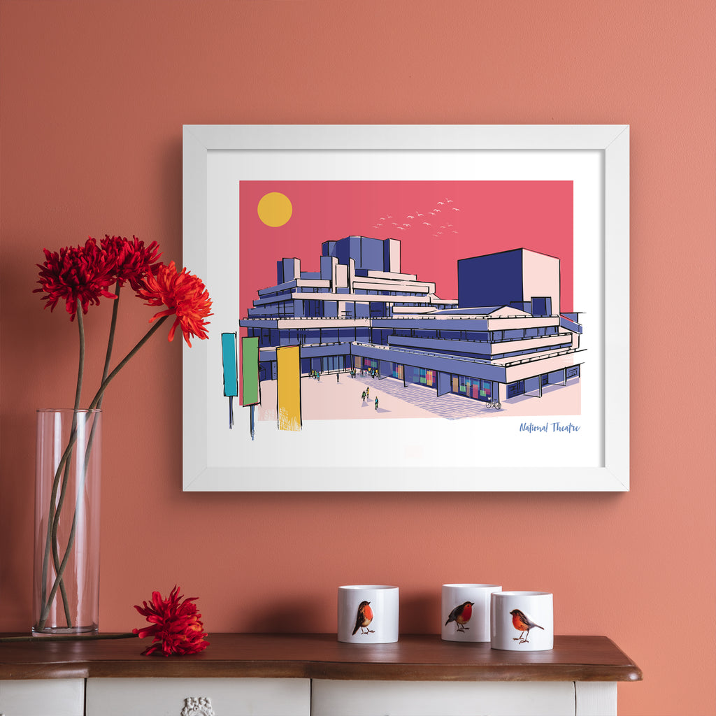 Colourful travel art print featuring the National Theatre in London, in vivid pastel colours. Title in the bottom right hand corner reads 'National Theatre'. Art print is hung up on a pink wall.