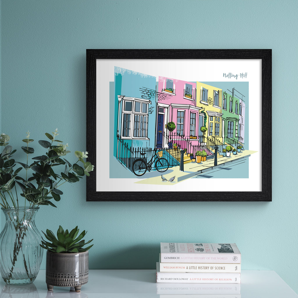 Vibrant travel art print featuring the colourful street of Notting Hill in London, amidst a brightly coloured background of pink, blue, yellow and green. The title in the top right hand corner reads 'Notting Hill'. Art print is hung up on a light blue wall.