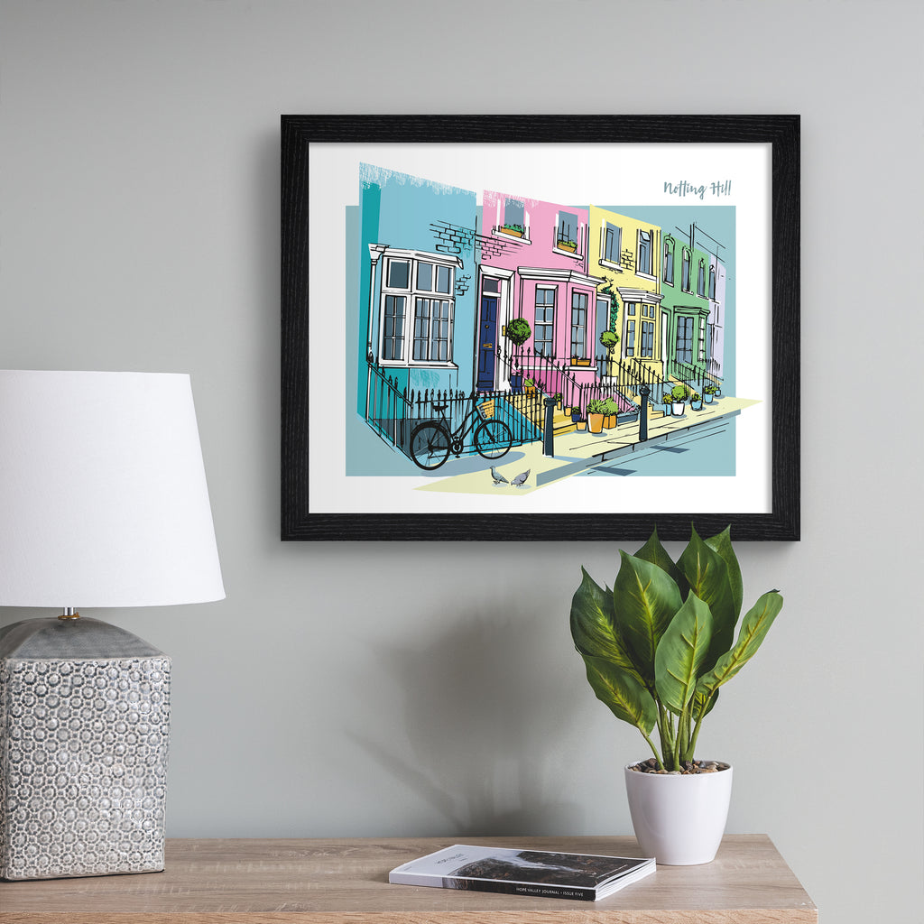 Vibrant travel art print featuring the colourful street of Notting Hill in London, amidst a brightly coloured background of pink, blue, yellow and green. The title in the top right hand corner reads 'Notting Hill'. Art print is hung up on a grey wall.