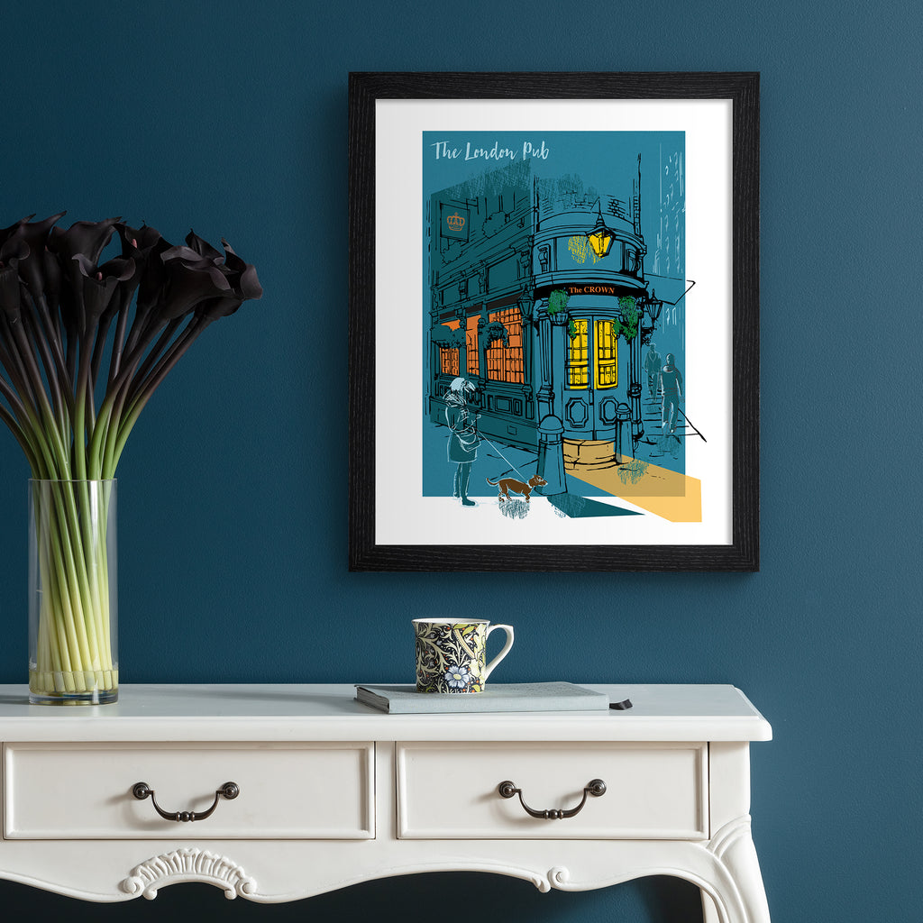 Vibrant travel art print featuring The London Pub, bathed in a dark blue and amber background. Title at the top reads 'The London Pub'. Art is hung up on a dark blue wall.