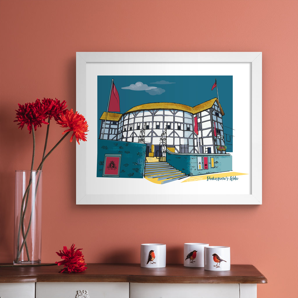 Colourful travel art print featuring Shakespeare's Globe in London, amidst a brilliant blue sky. Bottom right hand corner title reads 'Shakespeare's Globe'. Art print is hung up on a pink wall.