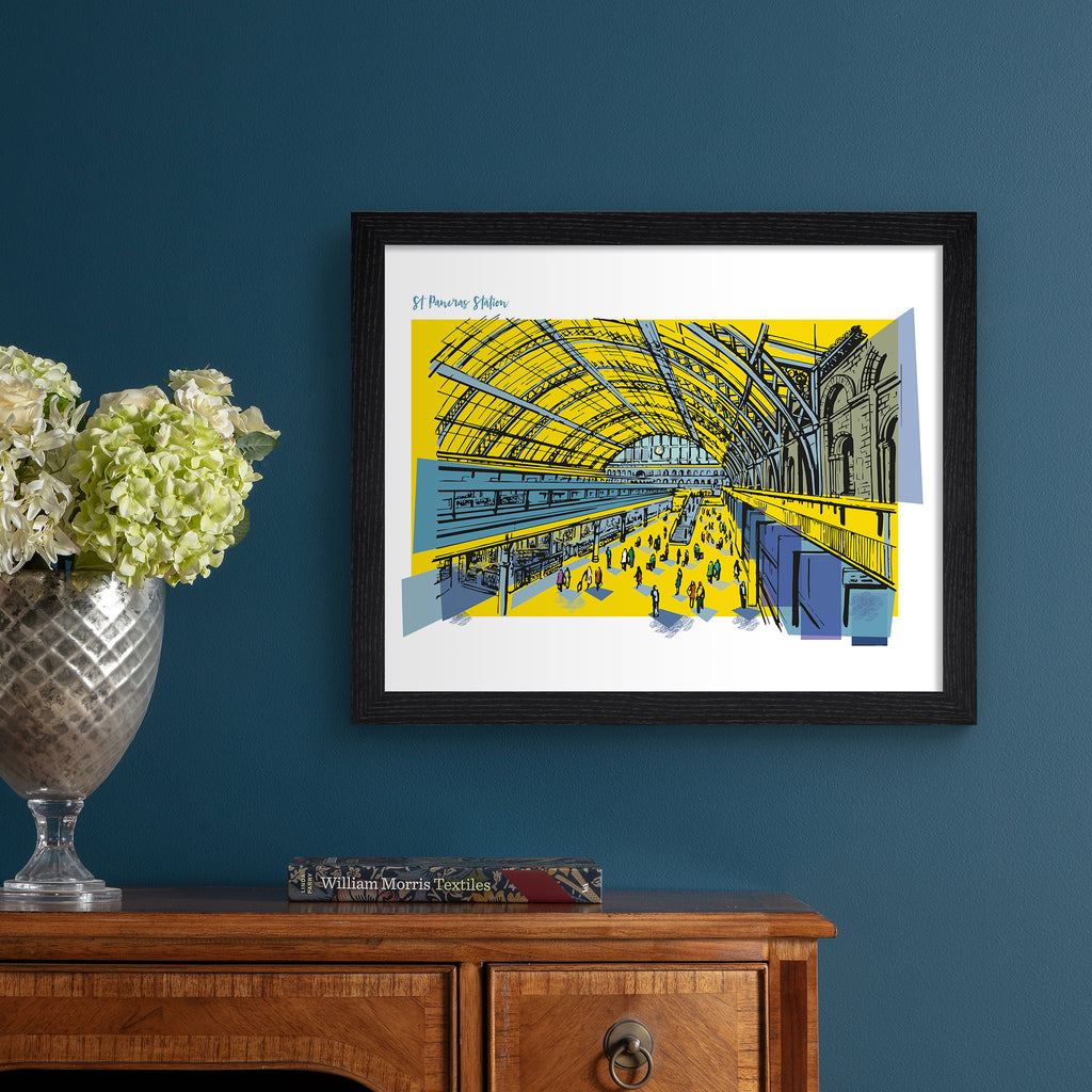 Striking travel art print featuring St Pancras Station in London, amidst a brightly coloured yellow background. Title in the top left reads 'St Pancras Station'. Art print is hung up on a dark blue wall.