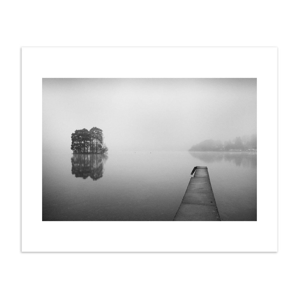 Moody black and white photography art print featuring mist flowing over still waters. 