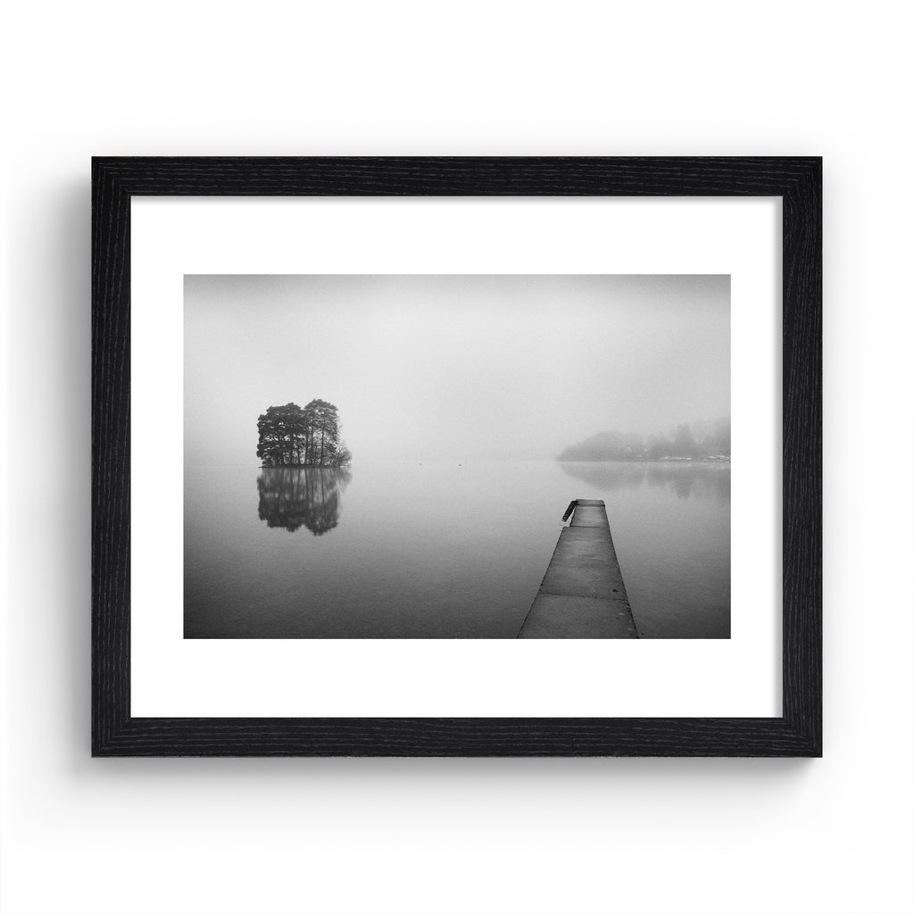 Moody black and white photography art print featuring mist flowing over still waters. Art print is in a black frame.