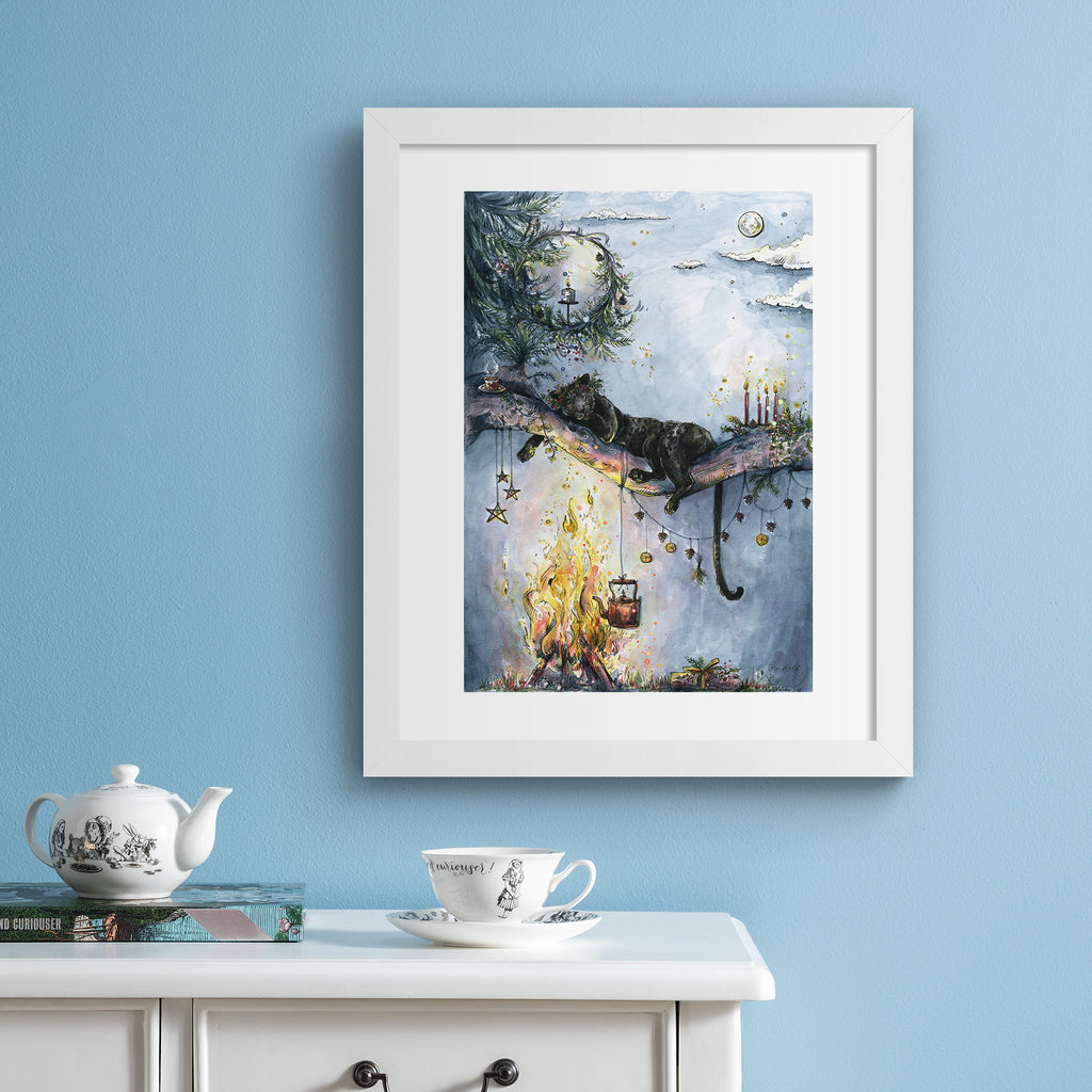 Cosy art print featuring a panther dozing peacefully on a branch, over a warm crackling fire. Art print is hung up on a blue wall.