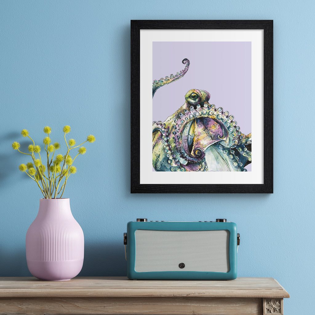 Playful art print featuring a curious octopus poking into the frame, in front of a pale purple background. Art print is hung up on a light blue wall.