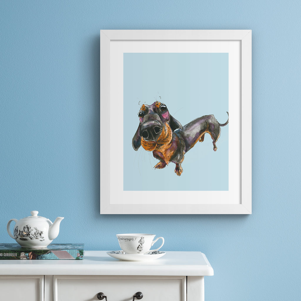 Playful art print featuring a curious dachshund dog, posing in front of a pale blue background. Art print is hung up on a blue wall.