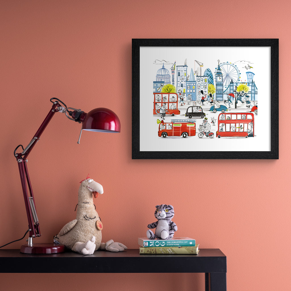 Colourful children's art print featuring playful animals exploring London's iconic landmarks. Art print is hung up on a pink wall.