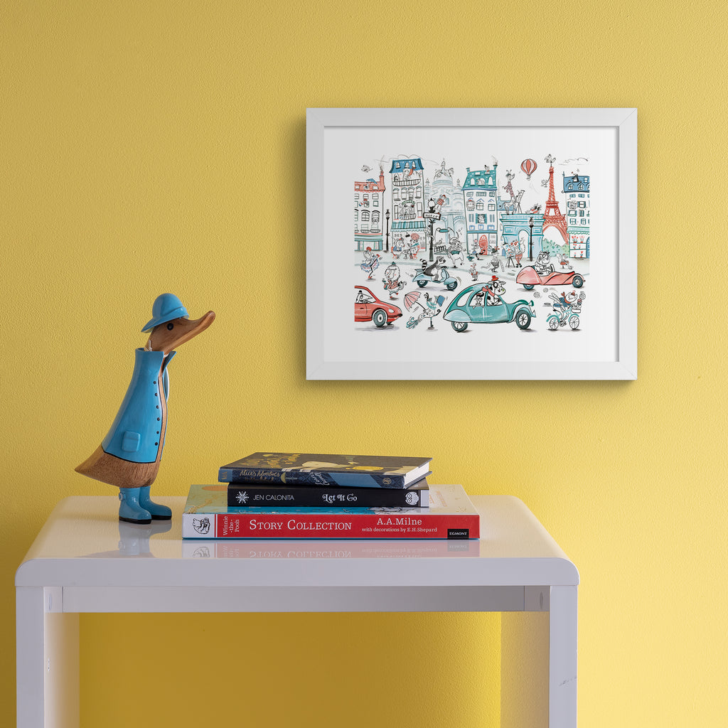 Colourful art print featuring playful animals exploring Paris. Art print is hanging up on a yellow wall.