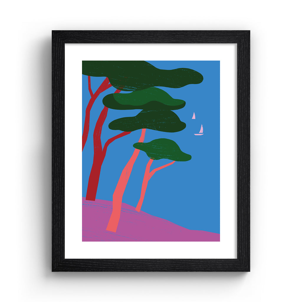 Bright art print featuring a beautiful tropical scene of trees overlooking the sea, with sailboats bobbing in the distance. Art print is in a black frame.