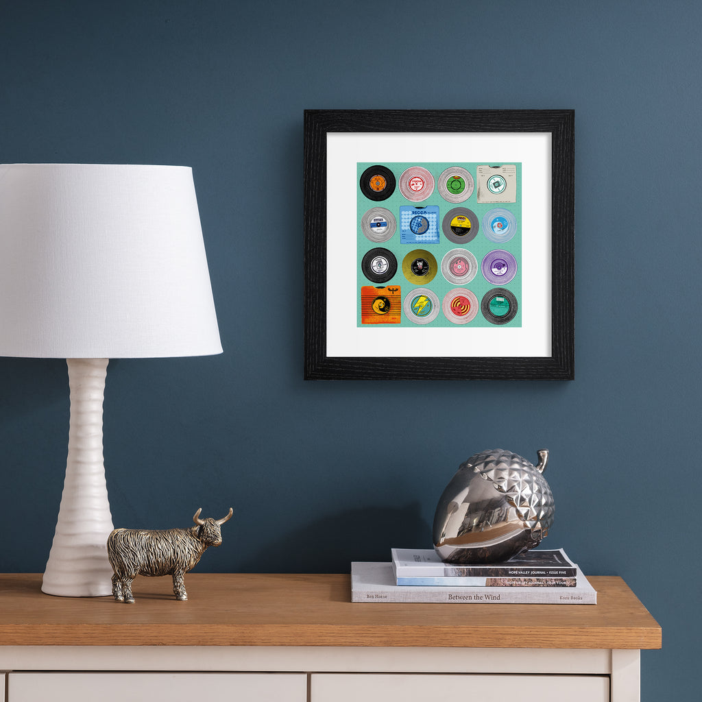 Bright art print featuring different types of vinyls on a bright blue background. Art print is hung up on a blue wall.