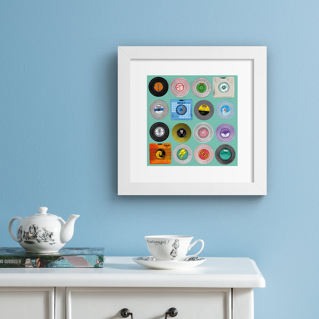 Bright art print featuring different types of vinyls on a bright blue background. Art print is hung up on a bright blue wall.