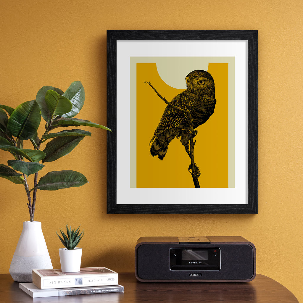 Striking art print featuring a detailed illustration of an owl perched on a branch, in front of a vibrant yellow sky. Art print is hung up on an orange wall.