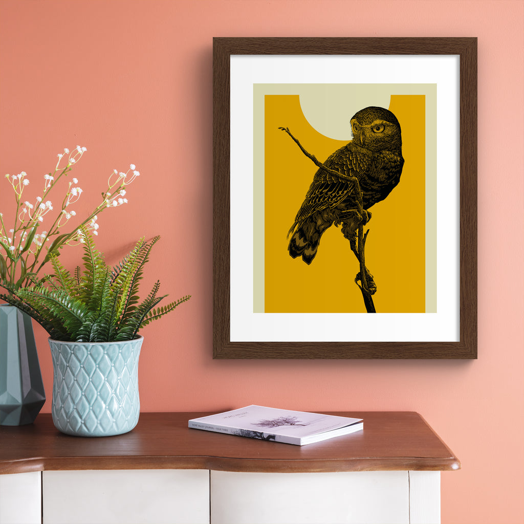Striking art print featuring a detailed illustration of an owl perched on a branch, in front of a vibrant yellow sky. Art print is hung up on a pink wall.