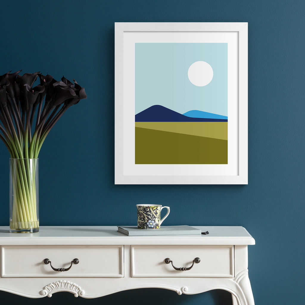 Minimalistic print featuring a beautiful mountain landscape. Art print is hung up on a dark blue frame.