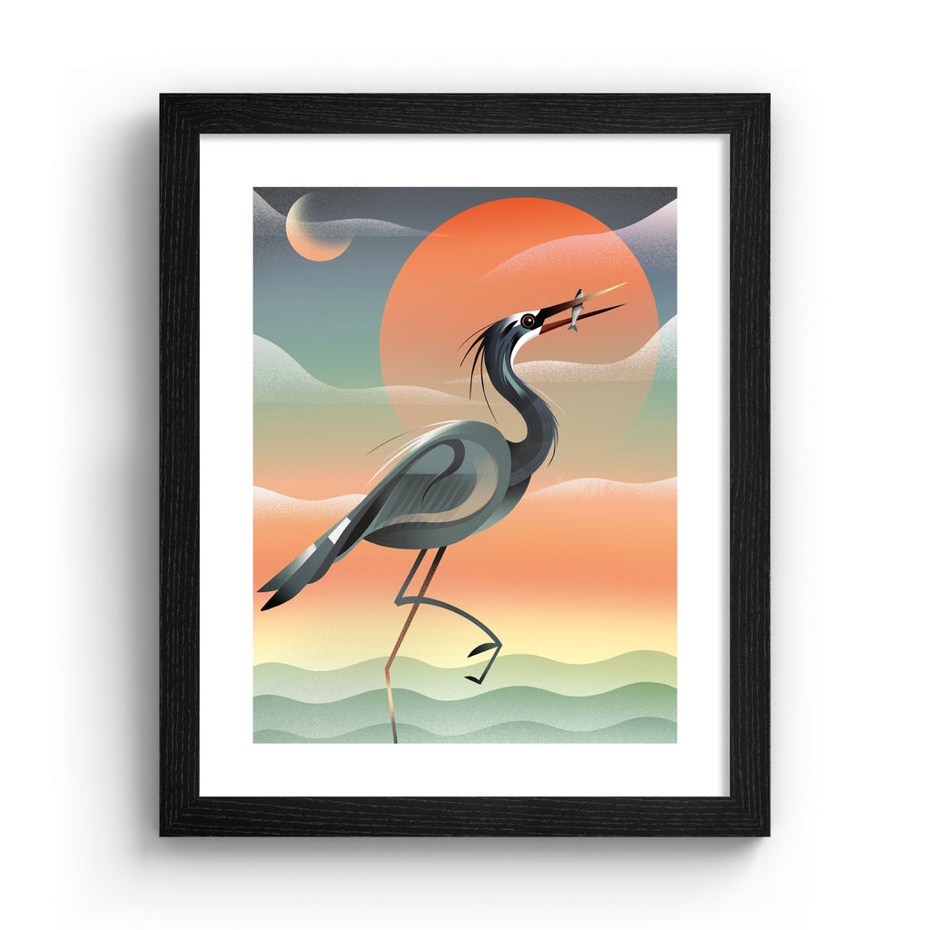 Striking art print featuring a grey heron posing in front of a stunning red sunset by the water. Art print is in a black frame.