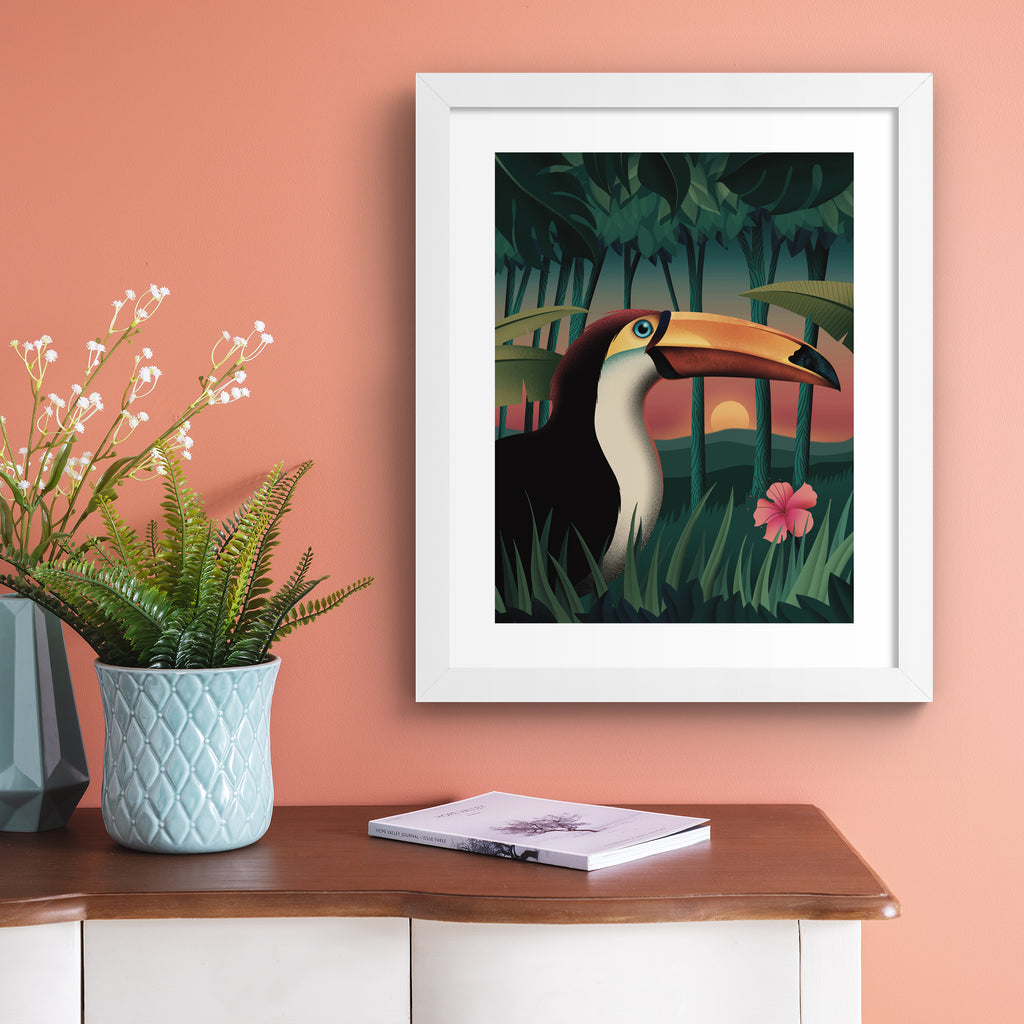 Vibrant art print featuring a sunset forest scene of a toucan standing amidst the trees. Art print is hung up on a pink wall.
