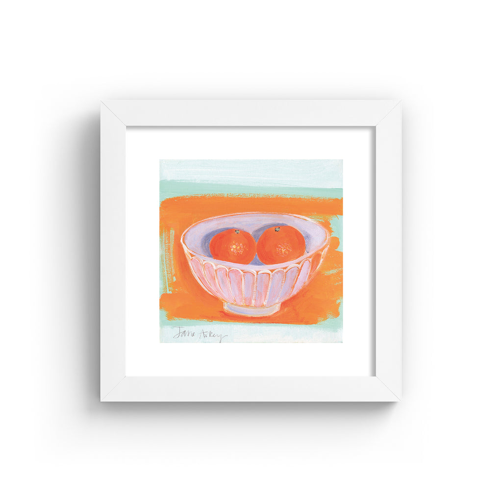 Minimalistic art print featuring oranges in a fruit bowl in front of a bright orange and blue background. Art print is in a white frame.
