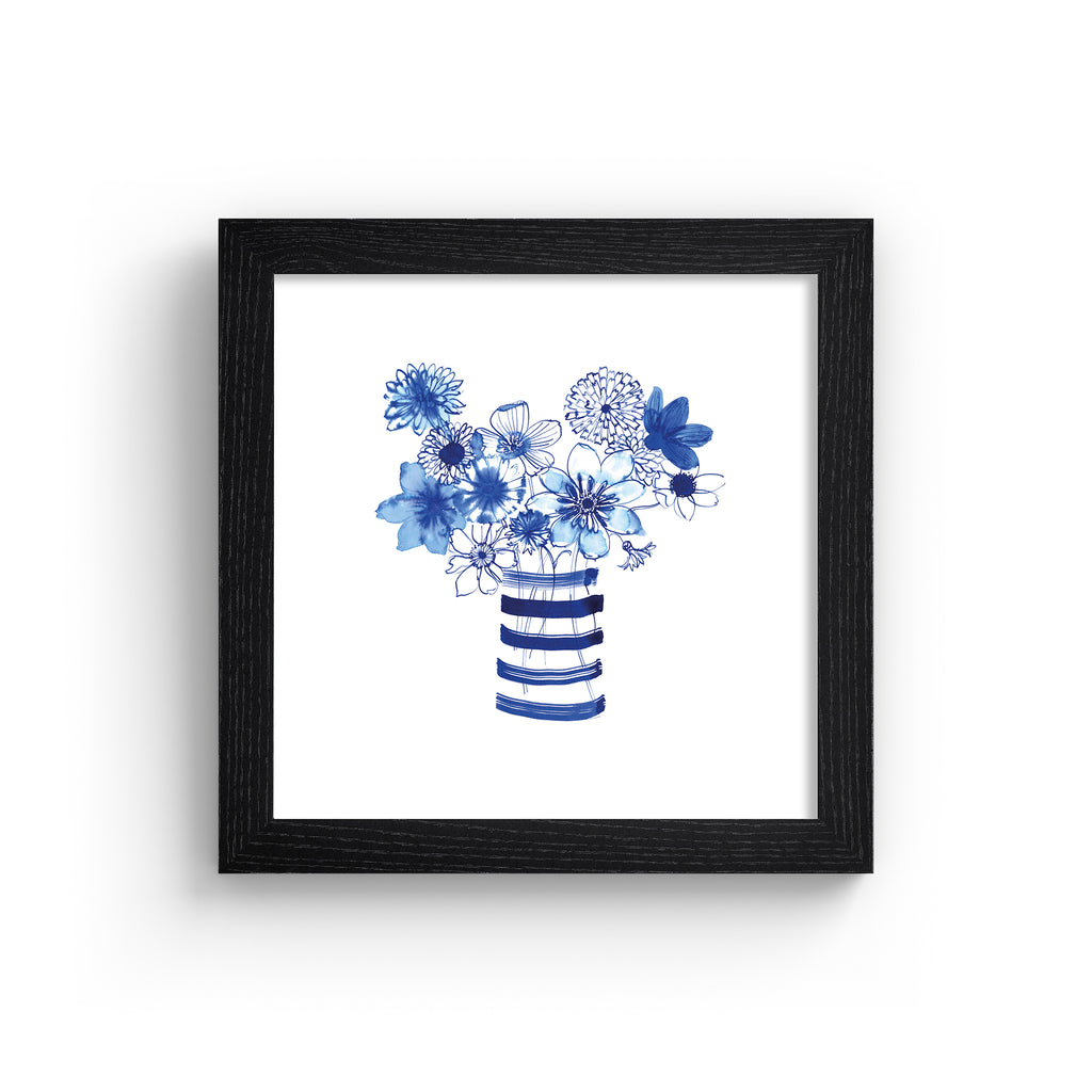 Colourful art print featuring indigo blue flowers in a striped vase. Art print is in a black frame.