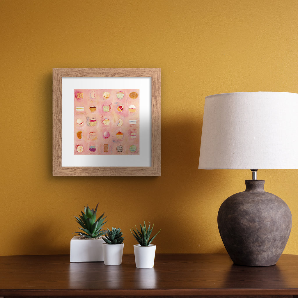 Abstract print containing a pattern of afternoon tea foods, laid out on a peachy pink background. Art print is in an orange frame.