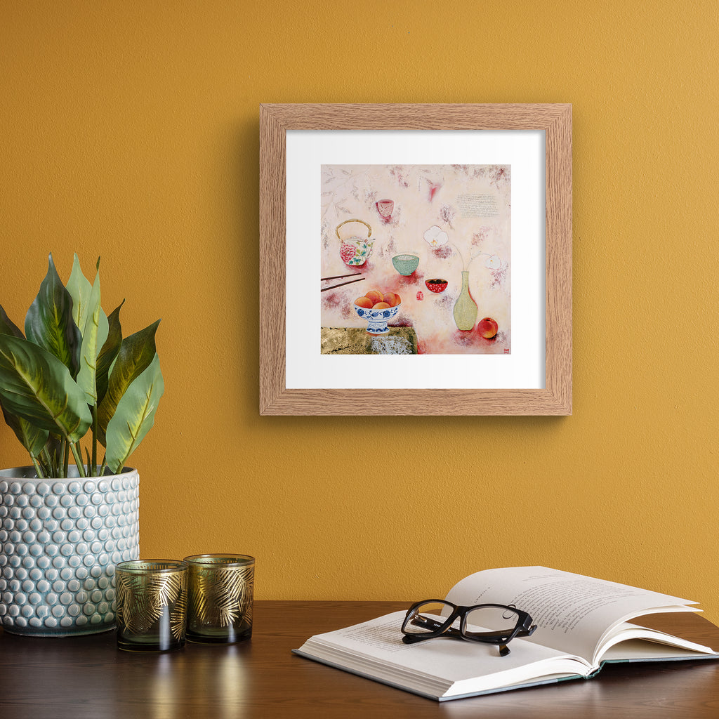 Cosy abstract print containing a food spread of peaches and tea, laid out on a pink background. Art print is hung up on an orange wall.