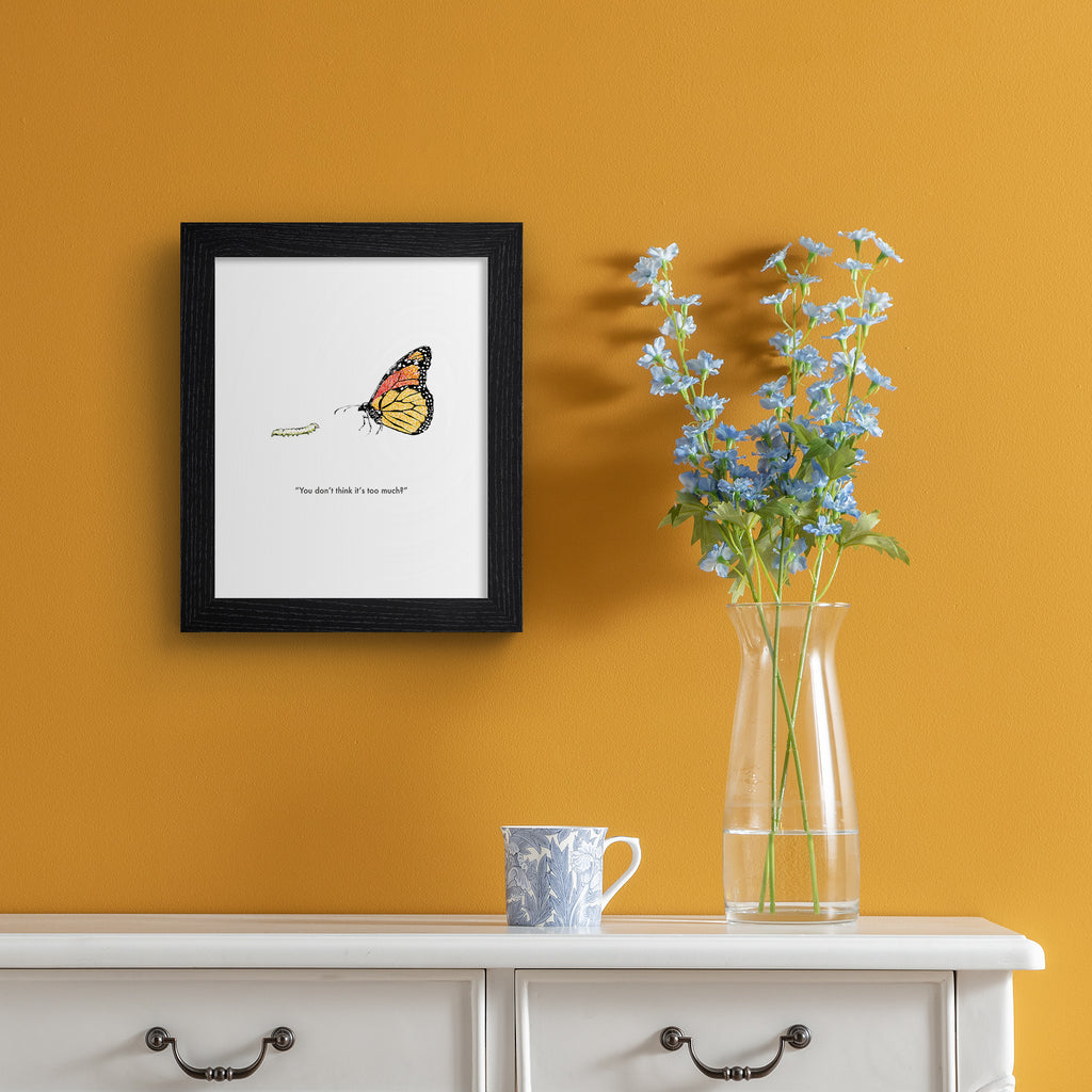 Humorous art print featuring an illustration of a butterfly standing with a caterpillar. Title below reads 'You don't think it's too much?'. Art print is hung up on an orange wall.