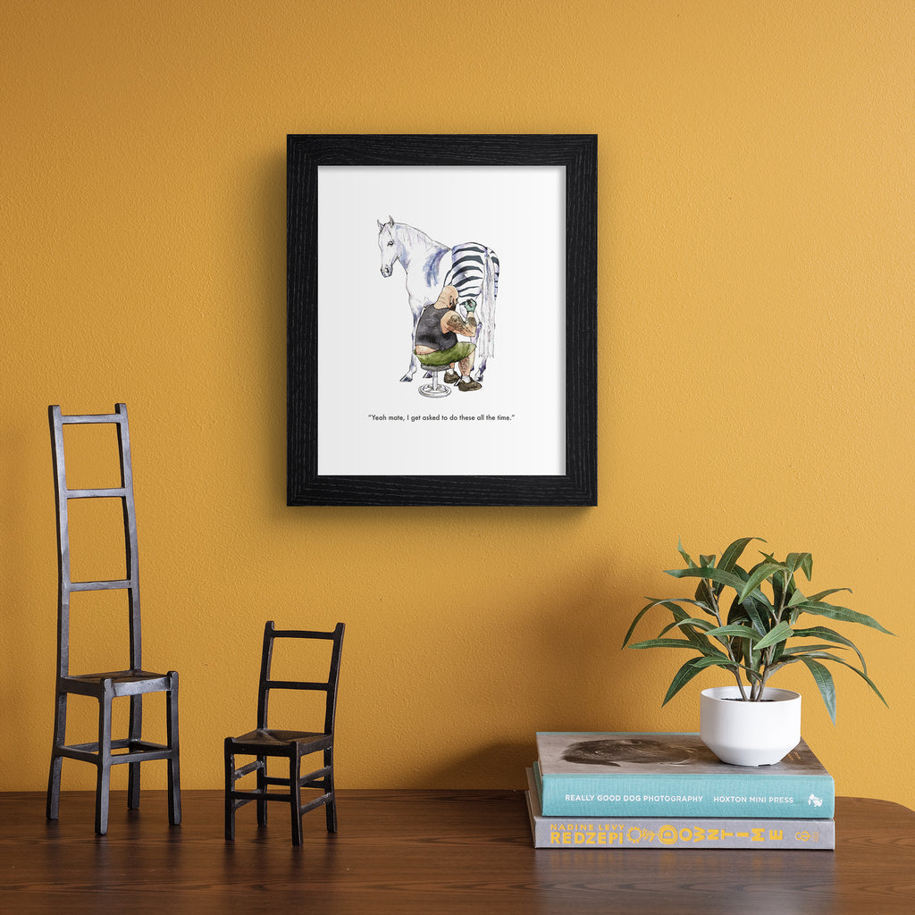 Humorous art print featuring an illustration of a horse getting a tattoo of zebra stripes. Text below reads 'Yeah mate, I get asked to do these all the time'. Art print is hung up on an orange wall.