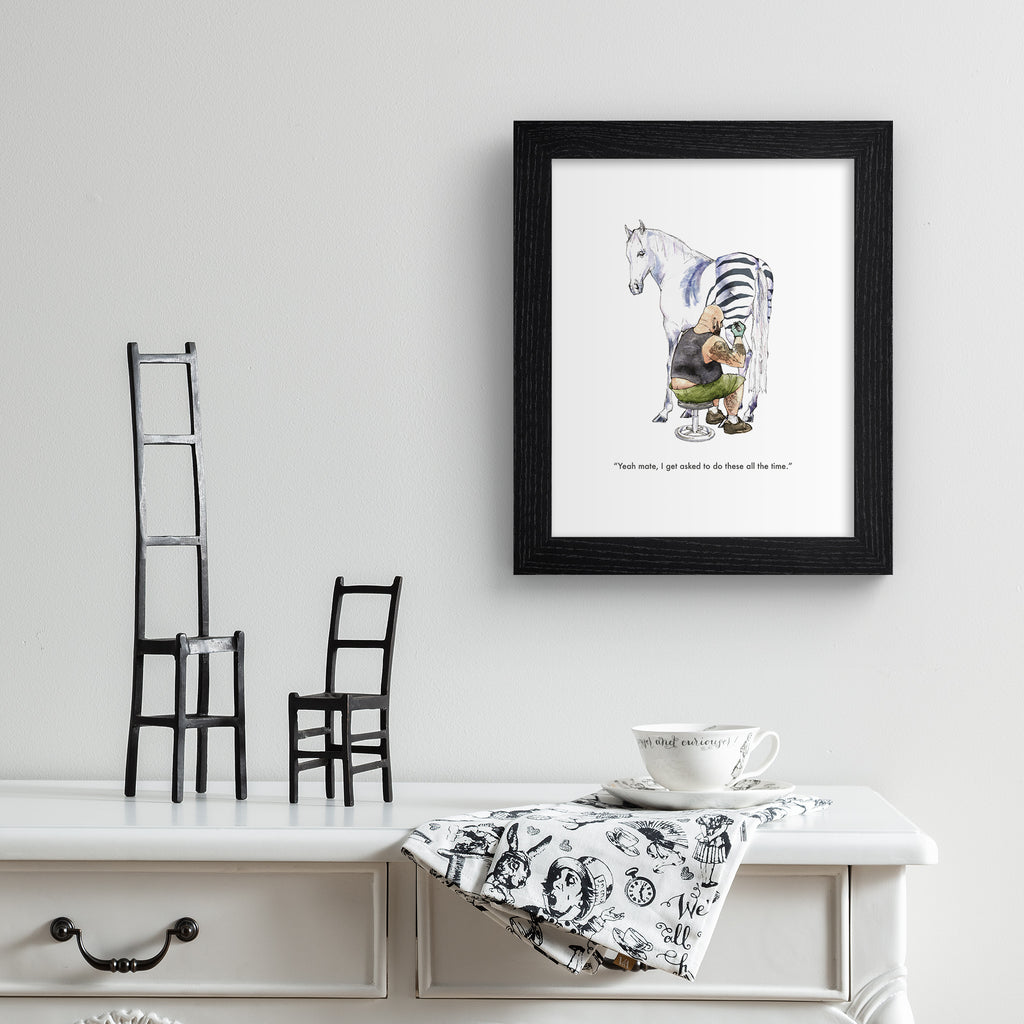 Humorous art print featuring an illustration of a horse getting a tattoo of zebra stripes. Text below reads 'Yeah mate, I get asked to do these all the time'. Art print is hung up on a white wall.