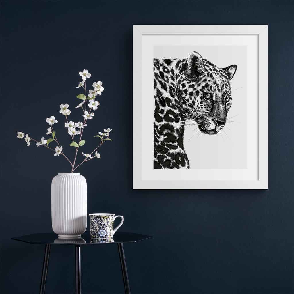 Beautiful art print featuring a detailed illustration of a leopard, in black and white.  Art print is hung up on a dark blue wall.