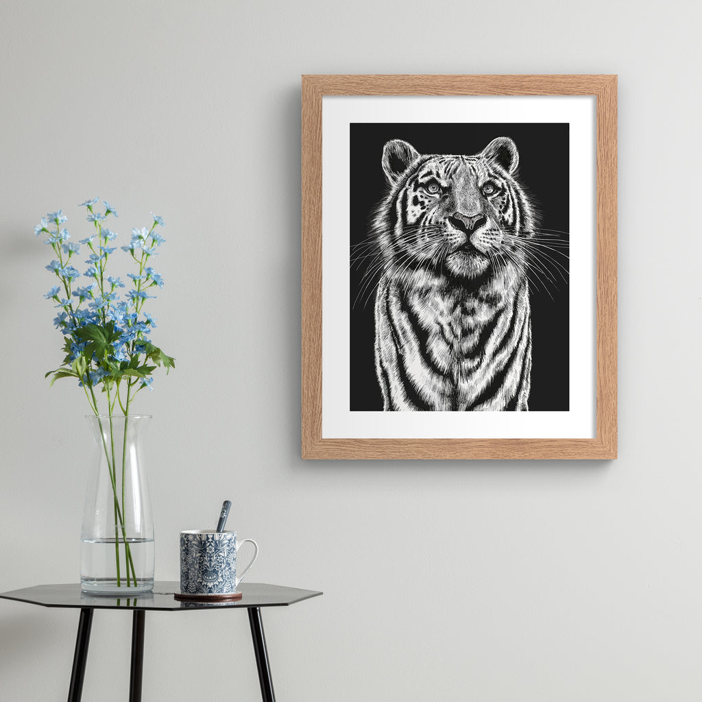 Striking art print featuring a detailed illustration of a tiger gazing upwards, in black and white. Art print is hung up on a beige wall.