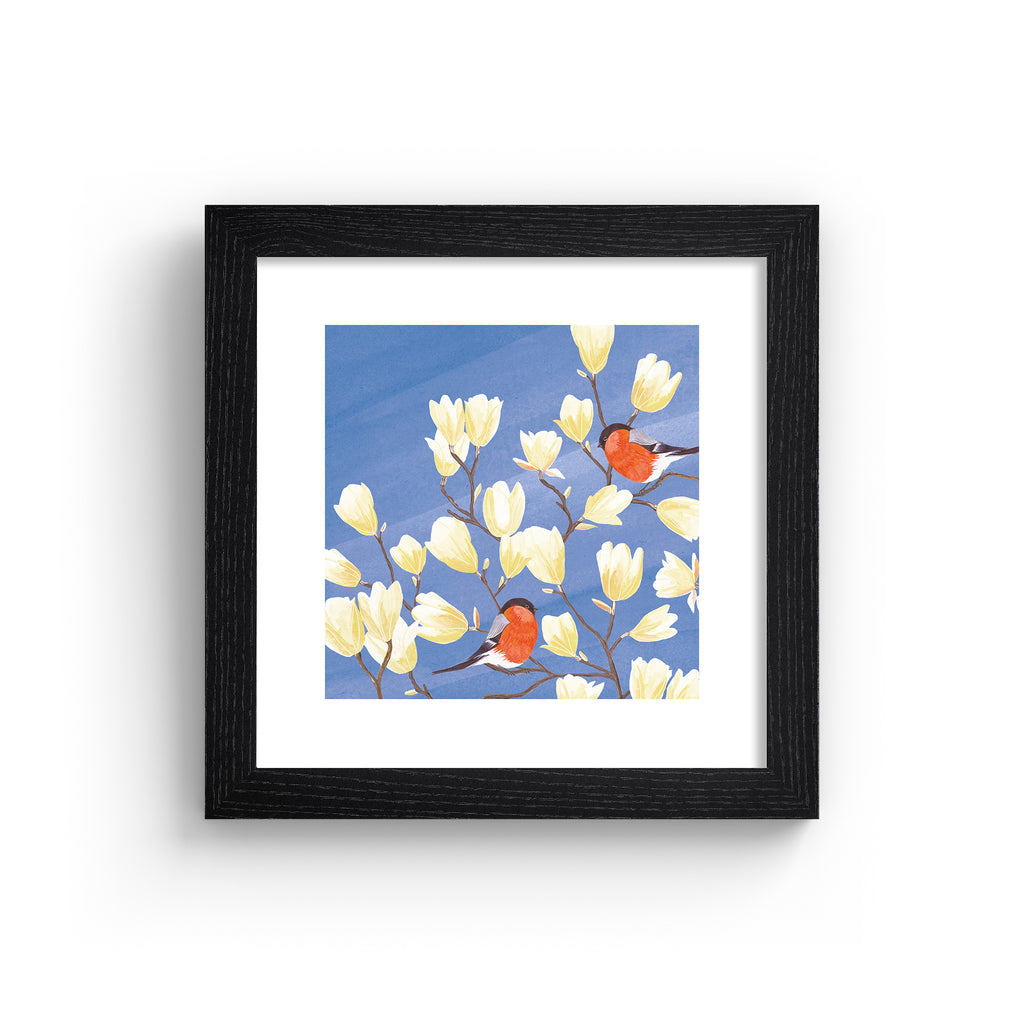 Stunning nature art print featuring two bullfinches perched in a blooming tree against a brilliant blue sky. Art print is in a black frame.